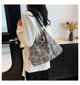 Detail view of large tote bag with brown geometric patterns and fashion tag on side
