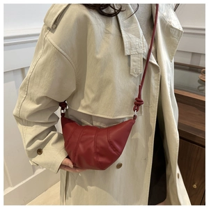 Détail du sac croissant rouge foncé avec surpiqûres verticales et bandoulière nouée