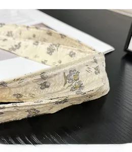 Detail of floral fabric handle with precision stitching on off-white cotton bag