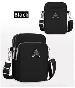 Detail view of the black nylon mini crossbody bag with multi-layer zippers and SPORT logo