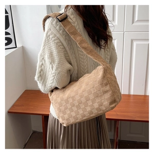 Detail view of large beige Hobo bag with textured pattern and adjustable shoulder strap