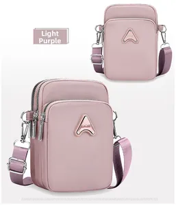 Close-up of light purple nylon phone bag featuring three zippers and SPORT logo badge