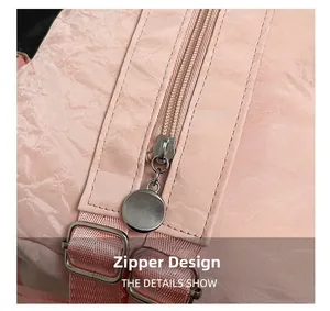 Detail of pink crinkled leather chest bag with silver metal zipper and nylon strap