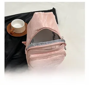 Detail view of pink chest bag interior with mesh compartments and multi-zipper structure