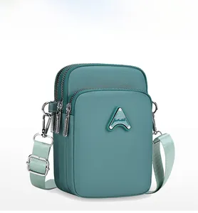 Side view of cyan nylon crossbody phone bag with three layered zipper compartments