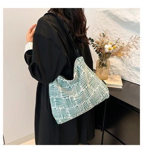 Detailed texture of green and white woven tote bag featuring geometric patterns