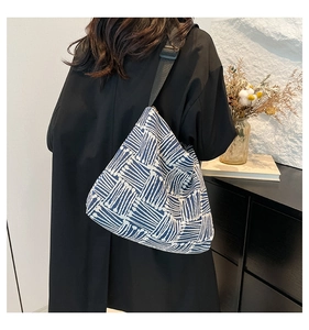 Detail of blue and white geometric striped tote bag with adjustable black nylon strap