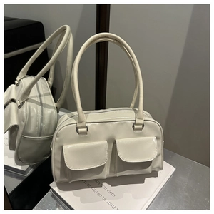 Détail du sac à main carré crème minimaliste avec doubles poches et longues anses