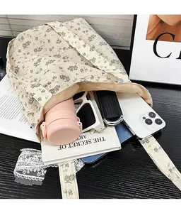 Floral print tote bag showing a spacious interior with personal items on a wooden desk