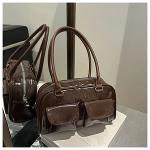 Reflet miroir montrant les détails d'un sac cabas en cuir verni marron avec deux poches avant