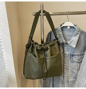 Detail view of army green nylon bucket bag with large capacity pockets and drawstring closure