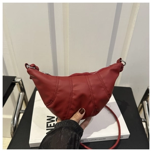 Détail du sac croissant rouge plissé en similicuir matelassé avec fine bandoulière