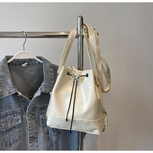 Gros plan du sac seau blanc crème avec boucle papillon argentée et fermeture à cordon