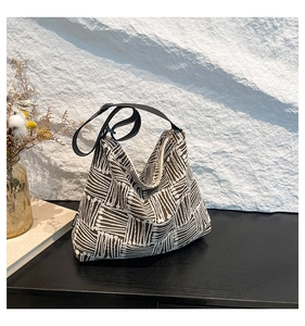 Detail of geometric pattern brown shoulder bag with a black nylon adjustable strap