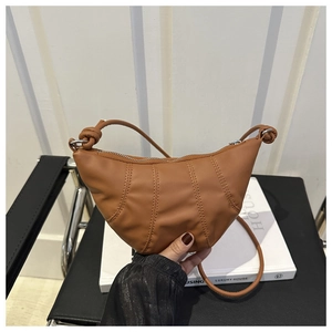 Détail du sac croissant marron avec surpiqûres et bandoulière à nœud élégante