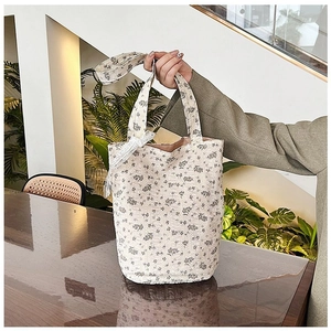 Detailed view of floral canvas tote bag with delicate lace bow and ditsy flower pattern