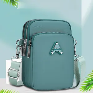 Detailed view of the three-layer zipper compartments on this teal crossbody phone bag