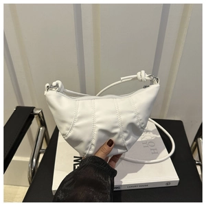 Détail du sac demi-lune blanc avec surpiqûres verticales et bandoulière à nœuds