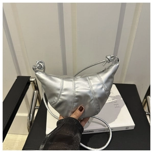 Détail du sac croissant argenté métallisé avec matelassage vertical et bandoulière nouée