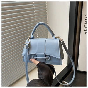 Close-up of light blue PU leather handbag with adjustable strap and metal hardware