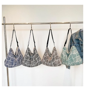 Detail view of four canvas tote bags with geometric patterns and adjustable straps