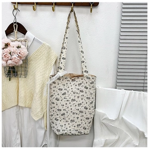 Detail showing the floral fabric texture and soft quilted pattern of this tote bag