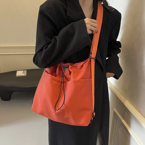 Minimalist bright orange nylon bucket crossbody bag with drawstring for women