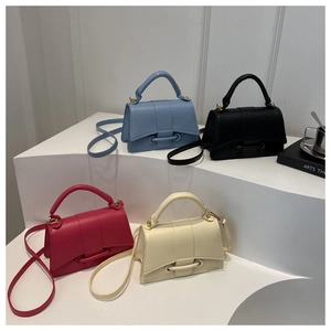Group display of four minimalist leather handbags in blue black pink and beige colors