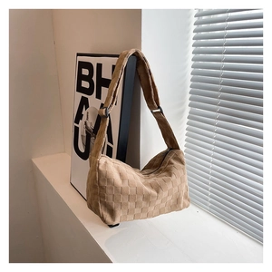 Detail of khaki woven checkerboard shoulder bag with adjustable strap and suede texture