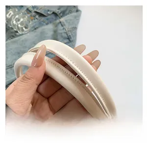 Detailed close-up of durable cream leather shoulder strap with reinforced double stitching