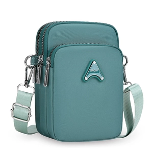Detail view of teal nylon crossbody phone bag featuring three zippered compartments and strap