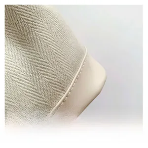 Close-up of beige herringbone canvas fabric and stitching detail on a casual tote bag