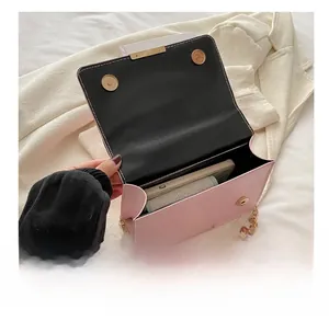 Pink quilted crossbody bag with gold chain strap showing interior phone storage space