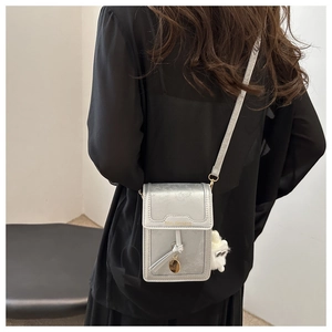 Piccola borsa per cellulare argento testurizzata con scritte dorate e ciondolo di peluche