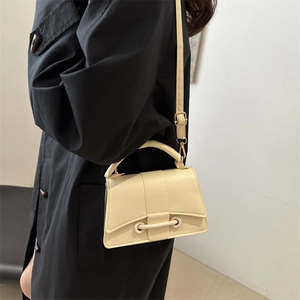 Minimalist cream faux leather crossbody bag with top handle and stylish metal buckle closure