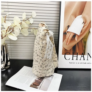 Detail of floral quilted cotton bag with elegant white lace bow and vintage flower pattern