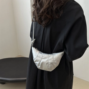 Sac croissant argenté minimaliste avec coutures verticales et finition métallisée