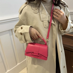 Minimalist pink crossbody small square bag worn with a white trench coat on model