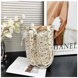 Detailed close-up of floral quilted tote bag with lace bow and cotton texture design