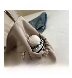 Close-up of canvas bucket bag featuring a drawstring side pocket with an umbrella and nylon strap