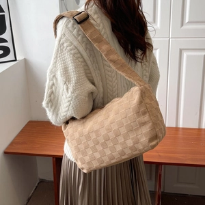 Beige woven leather crossbody bag with adjustable wide shoulder strap and tote design