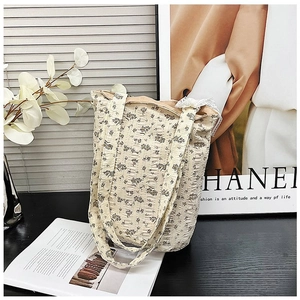 Detail of floral quilted tote bag featuring lace trim and a secure zipper closure