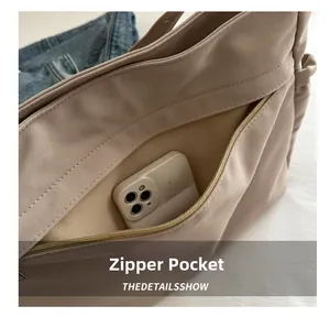 Detailed macro view of the interior zipper pocket holding a smartphone in a canvas tote bag