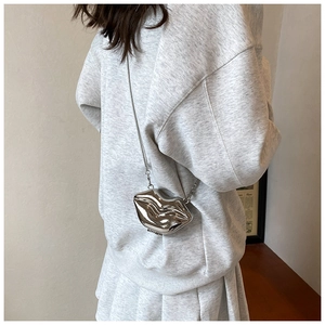 Detail van zilveren lippenvormige acryl mini-clutch met metalen ketting op model