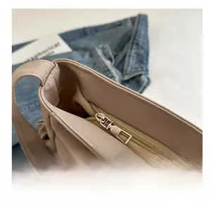 Detail of smooth silver zipper closure on beige canvas bucket bag with neat stitching