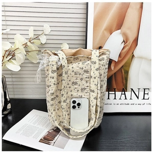 Detailed view of floral canvas bucket bag with lace trim and interior storage space