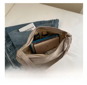 Detail of the large beige canvas tote bag showing spacious interior for tablets and books