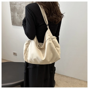 Detail view of large cream canvas hobo bag with adjustable strap and side drawstring texture