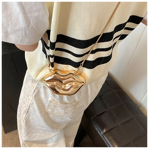 Model view of a metallic gold lip-shaped crossbody bag with a slim metal chain strap