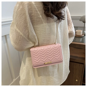 Close-up of pink chevron quilted shoulder bag with gold chain strap and metal lock